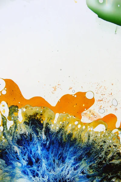 Colored liquids mixed together in fluid creating colorful abstract painting