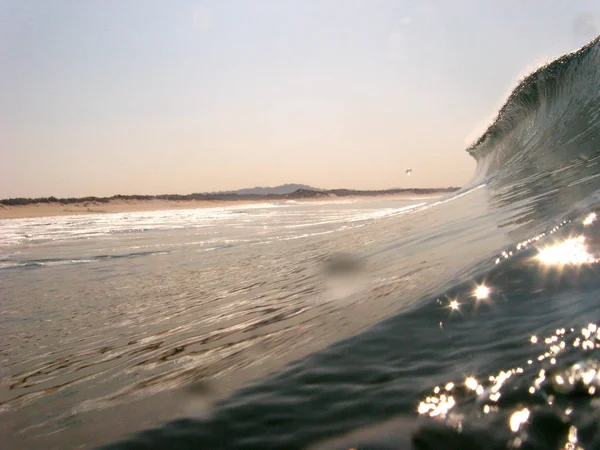 海浪冲破了海岸 喷出了浪花 白色的水和水面反射出的光 — 图库照片