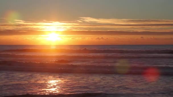 小さな波 美しい赤い日光と水の表面の反射で海に沈む夕日 — ストック動画