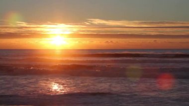 Sisli bir gün batımı sırasında Atlas Okyanusu kıyısında dalgaları