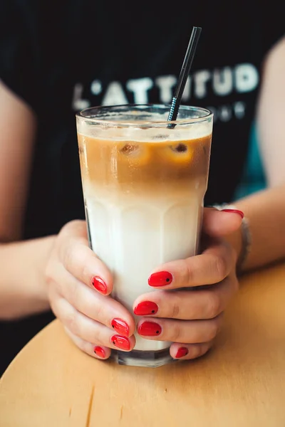 Iced coffee with milk. Iced coffee latte . Woman holding glass cup of iced coffee. Manicure minimal style. Minimalist Fashion and beauty. Coffee time. Morning mood.