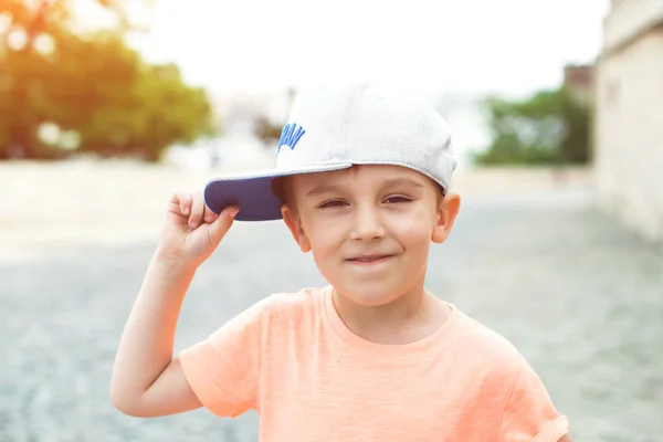 小城市男孩在户外 可爱的微笑的孩子的肖像 城市风格 城市的孩子们 快乐的童年 儿童时尚 棒球帽里那个可爱的小男孩 城市街道上的时髦小男孩 — 图库照片