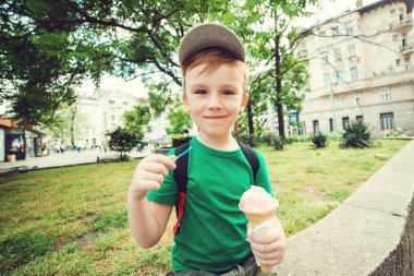 Dondurma açık havada yemek sevimli çocuk. Kentsel çocuk dondurma yaz günde zevk. Gülümseyen mutlu çocuk. Yaz tatili