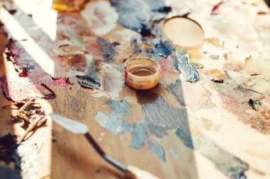 Renkler ve fırçalar ile İşyeri Ressam paleti. Palet renklerini, yaratıcı bozukluğu, sanat. Sanatçının paleti, yakın çekim. Parlak yağlı-boya paleti closeup arka plan görüntüsü