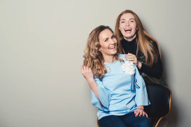 Mutlu genç kadın gülerek ve gülümseyerek, izole üzerinde gri. Genç arkadaşlar. Kadın moda. Uzay kopyalayın. Kadınlar birlikte eğlenin. Dostluk, yaşam tarzı, insanlar ve moda kavramı