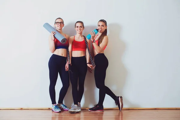 年轻运动妇女后 在健身室训练 运动和健康的生活方式概念 在白墙前站在一起的运动衫的女性群体 女孩健身运动 — 图库照片