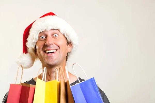 Verrast Man Kerstmuts Houdt Boodschappentassen Geïsoleerd Wit Kerstmis Winkelen Verkoop — Stockfoto