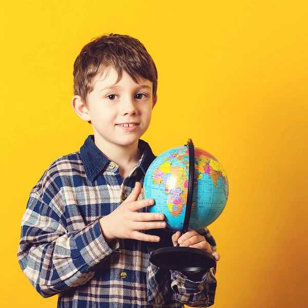 Любопытный Мальчик Держит Карту Земного Шара Маленький Путешественник Изолированный Желтом — стоковое фото