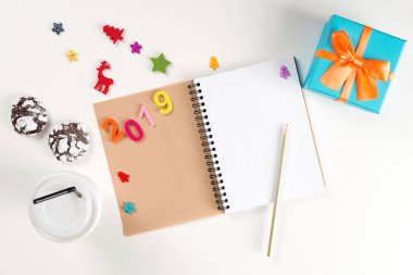 Yeni yıl 2019. Not defteri ve kalem beyaz masada açıldı. Yeni yıl kararları kavramı. Yeni yıl arka plan. Noel tatili. Xmas. Yeni yıl ya da Noel için hedefler. Noel dilek listesi