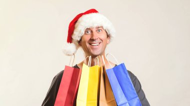 Noel alışveriş online. Yeni yıl hediyeleri. Mutlu Noel alışveriş torbaları, üzerinde beyaz izole ile. Uzay kopyalayın. Noel alışveriş, satış ve indirimler kavramı. Alışveriş keyfini Noel şapkalı adam