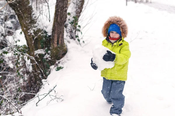 快乐的小男孩在雪地里玩耍 在冬日玩得开心的小孩 滑稽的男孩穿着温暖的外套 冬季天气 孩子们的冬季活动 快乐和健康的童年 — 图库照片