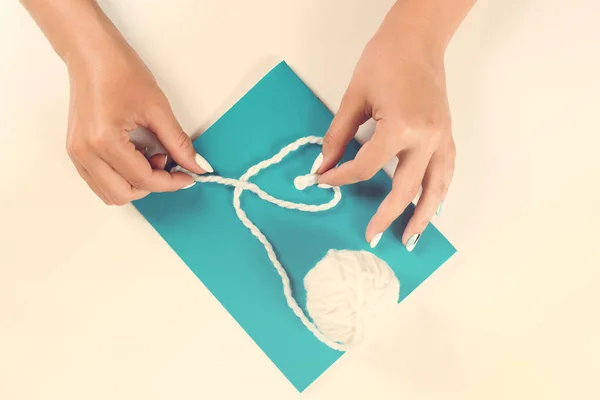 Mãos Femininas Fazendo Símbolo Forma Coração Fio Branco Papel Azul — Fotografia de Stock