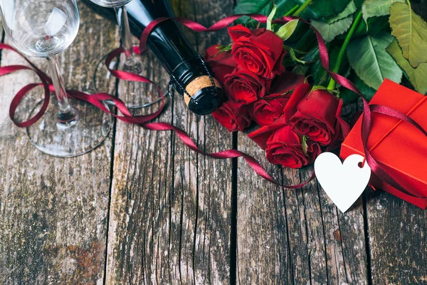 幸せなバレンタインデー 美しい赤いバラです バレンタインの日カード 素朴なスタイル 領域をコピーします 愛のカードです バレンタイン ギフトの花 シャンパン グラスと木の板でロマンチックなバラ — ストック写真