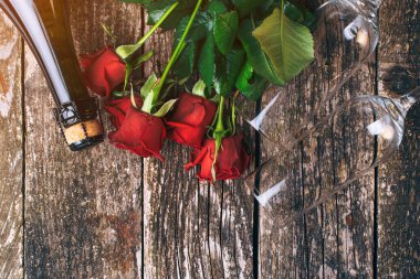 Sevgililer günü kartı. Güzel kırmızı gül. Düz yatıyordu kompozisyon. Şişe şampanya. Üstten görünüm. Ahşap masa üzerinde şampanya bardağı. Romantik olay. Sevgililer tebrik kartı. Uzay kopyalayın. Rustik tarzı