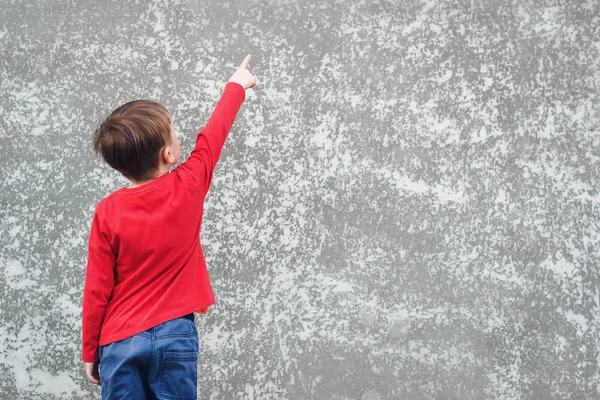 Kleiner Junge Zeigt Auf Leeren Platz Betonwand Rückansicht Des Kindes — Stockfoto