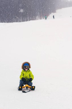 Mutlu bir çocukluk karlı kış günde halletme. Bir kızak sürme yürümeye başlayan çocuk. Kış tatili. Mutlu çocukluk. Noel tatil. Kış spor ve eğlence. Kış halletme vaktinizi mutlu çocuk