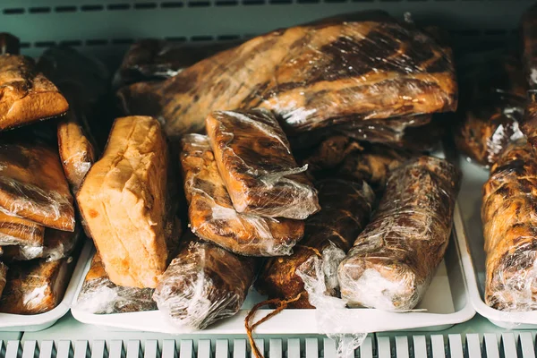 Homemade sausages on a farmers market. Traditional street food. Tasty delicious smoked dried sausages at plastic box.