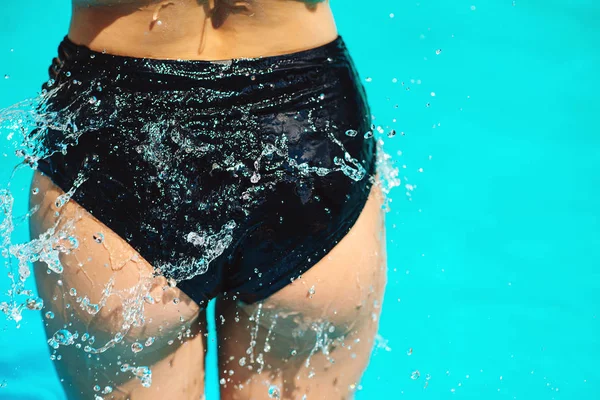 Sexy model\'s ass in black bikini at water. Sexy wet buttocks. Closeup body of fashion model girl in pool