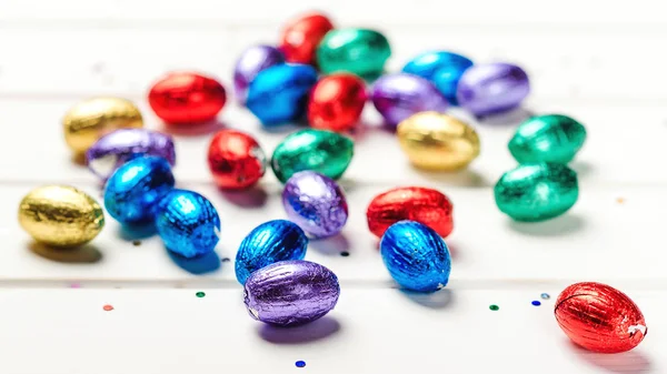Oeufs de Pâques festifs à table. Bonne carte de Pâques. Mini oeufs colorés éparpillés sur fond blanc . — Photo