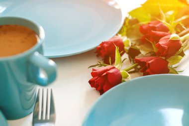 Sabah kahvaltı mutfak masasında. Kırmızı gül ve tablo sütlü kahve. 