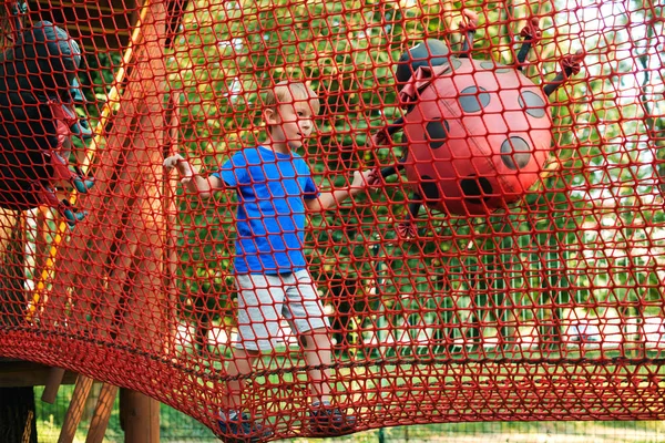 Happy Boy övervinner hinder i Rope Adventure Park. Sommarsemester koncept. — Stockfoto