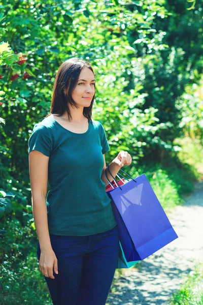 Szczęśliwa młoda kobieta korzystających sezonowych sprzedaży z kolorowych torby na zakupy, patrząc na bok. Moda damska. — Zdjęcie stockowe