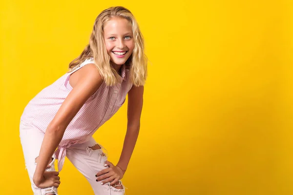 Menina pré-adolescente bonito vestindo roupas de verão moda posando no fundo amarelo . — Fotografia de Stock