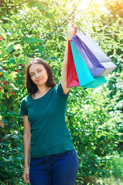 Gelukkig brunette vrouw na grote winkel verkoop, het houden van kleurrijke boodschappentassen. — Stockfoto