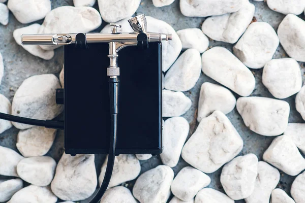 Makyaj için modern aerograf. Taşlara hava fırçası, kopya alanı. Profesyonel makyaj airbrush. Düz döşeme, üst görünüm.