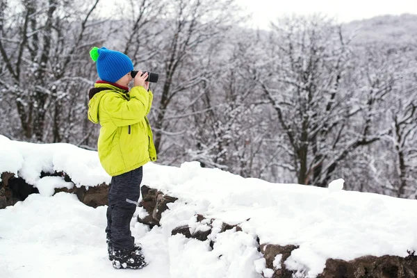 ?esploratore della natura del capretto sveglio nella foresta di inverno. Binocolo bambino esploratore a natura invernale. Vacanze invernali . — Foto Stock