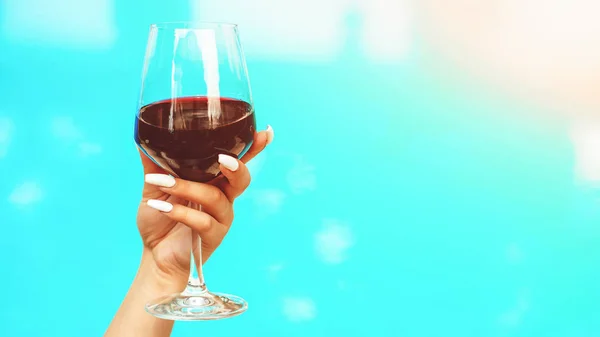 Wine and water's view. Female hand holding glass of red wine. Travel vacation. Luxury cruise. — Stock Photo, Image