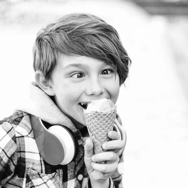 Šťastný kluk, který jedl zmrzlinu. Roztomilá chlapeček má zmrzlinu v kužele vafle. Šťastné letní období. — Stock fotografie