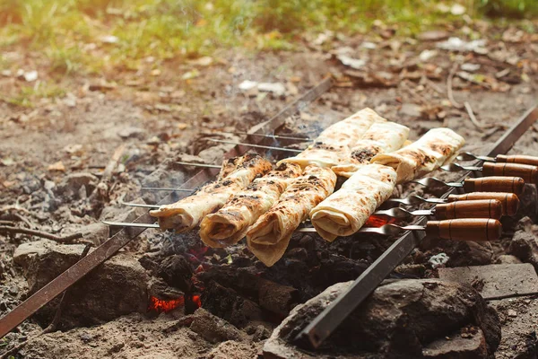 Picnic time with cooking pita bread. Lavash on the grill. Stuffed pita on the grill at nature. — Stock Photo, Image