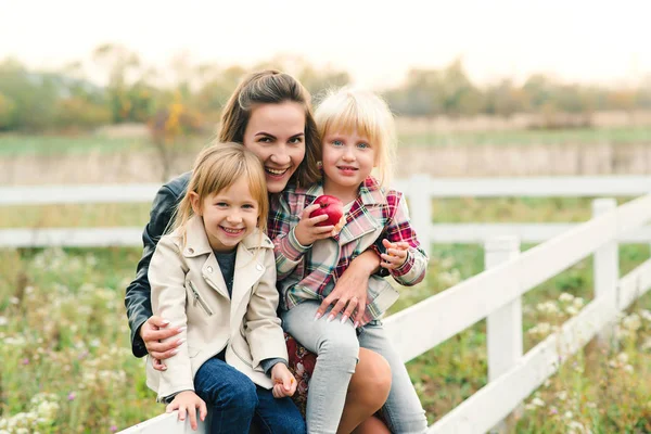 Mladá matka a její dcerušky na venkově. Šťastná rodina spolu s přírodou. Vztahy, dobrá nálada a módní koncepce. — Stock fotografie
