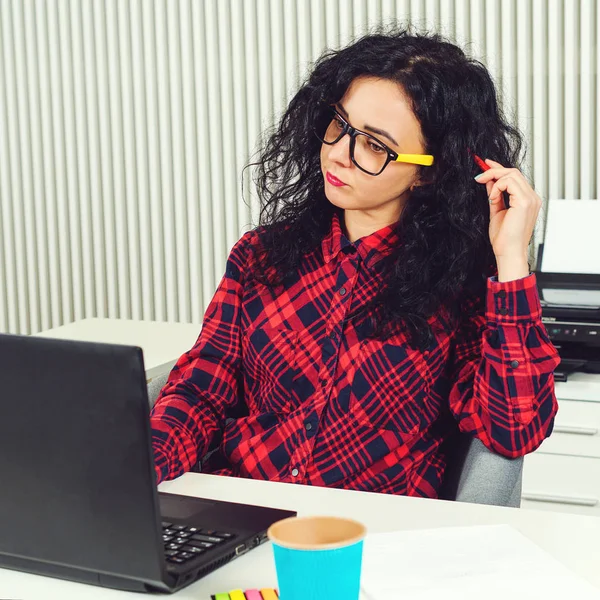 Junge konzentrierte Frau, die im Büro mit Laptop arbeitet. Coworking-Konzept. Frau arbeitet an neuem Startup-Projekt. — Stockfoto