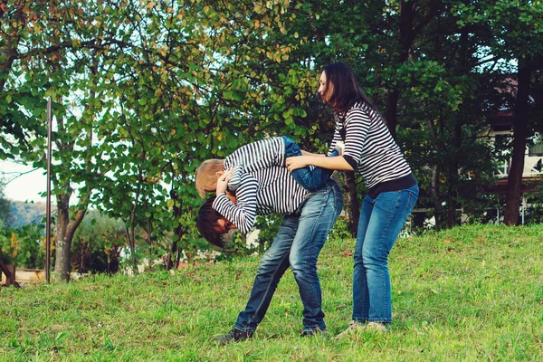 Família feliz passar o tempo juntos em um parque. Jovem família ao ar livre se divertindo. Boas festas — Fotografia de Stock