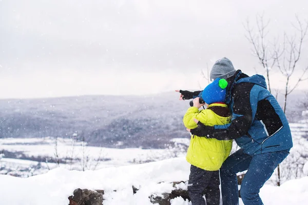 Батько і син шукають гори в зимовій природі. Дитячий погляд — стокове фото
