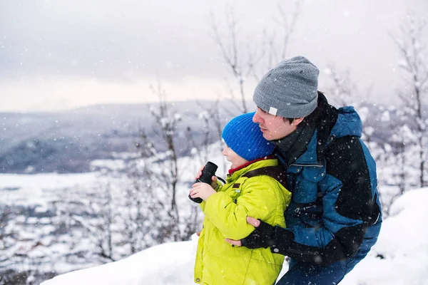 Padre e hijo jugando al aire libre en invierno. Niño mirando a monocu — Foto de Stock