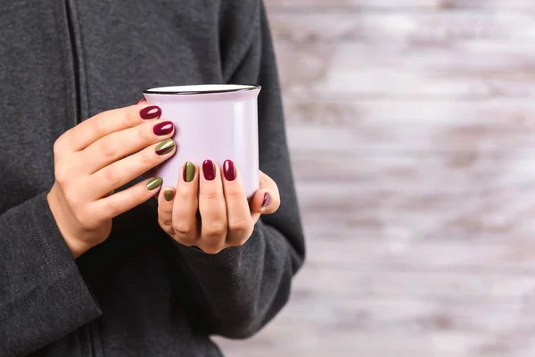 Manos femeninas sosteniendo una taza de té caliente. Chica con la mano hermosa manicura, de cerca. Bebida, moda, mañana — Foto de Stock