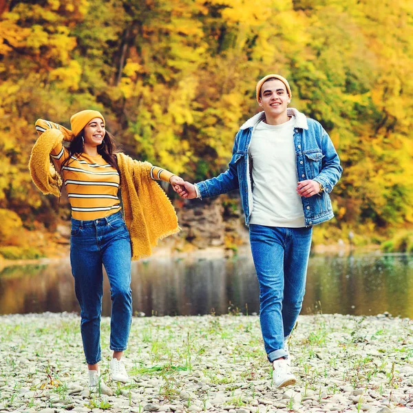 Νεαρό ζευγάρι της μόδας στην αγάπη τρέχει μαζί το φθινόπωρο. Αγάπη και διασκέδαση. Φθινοπωρινή μόδα, εποχή, τρόπος ζωής. — Φωτογραφία Αρχείου