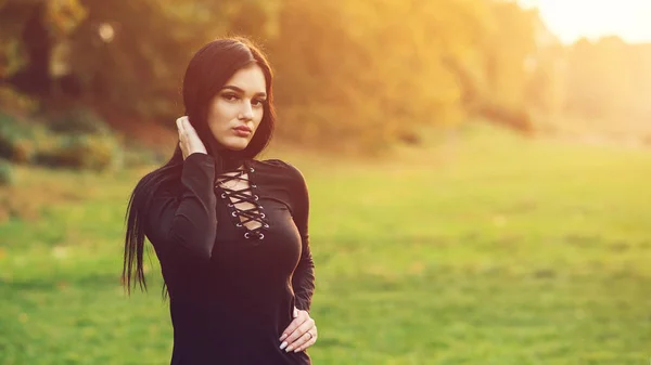 Σέξι μελαχρινή κοπέλα που φοράει μαύρο φόρεμα έξω. Γυναικεία μόδα και τρόπος ζωής. Αισθησιακά χείλη, προσωπογραφία ομορφιάς. — Φωτογραφία Αρχείου