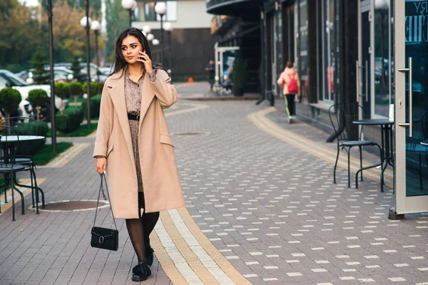 Young stylish businesswoman walking on the street. Young woman talking by phone outdoors. — 图库照片