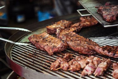 Taze ızgara et. Sokak pazarı. Şef et hazırlıyor, kapatın. Sokak festivali. Barbekü, barbekü. Izgara domuz pirzolası. Yemek servisi, parti. Şefin elinde sıcak domuz pirzolası var. Sokak yemeği..