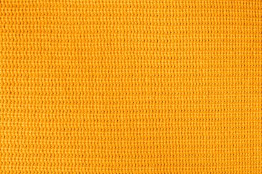 Turuncu tekstil arkaplan örgüsü. Yün arka plan, üst manzara. Soyut, taze, sarı, örülmüş arka plan dokusu. Turuncu örülmüş akrilik iplikler, yakın plan..