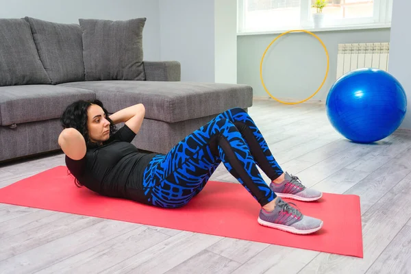 여자가 바닥에서 운동을 매트에서 운동하는 조절의 개념이다 기간에 거실에서 훈련하고 — 스톡 사진