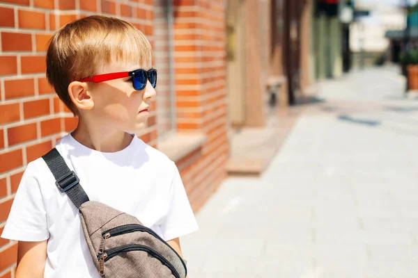 시가지에서 선글라스낀 귀여운 아이야 티셔츠를 가방을 밖에서 패션이야 선글라스를 야외에서 — 스톡 사진