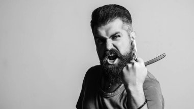 Sakallı, şık saçlı bir adam. Berber dükkanı reklamı. Berber adam ustura tutar. Klasik usturası olan acımasız bir adam. Berber dükkanı konsepti. Klasik berber dükkânı ve tıraş. Siyah ve beyaz.