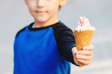 Şehir merkezinde dondurma yiyen bir çocuk. Mutlu bir çocukluk. Yaz yürüyüşüne çıkmış tatlı bir çocuk. Lezzetli meyveli dondurma. Yaz tatili.