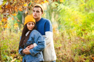 Aşık mutlu bir çift. Güzel sonbahar doğası. Sonbahar modası. Tarz sahibi kadın ve erkek birlikte eğleniyor. Sonbahar havası, yaşam tarzı. Genç moda çifti ormanda yürüyüşe çıkmış..