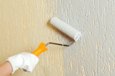 Paten fırçasının yanındaki işçi boyası duvarı. Banner, metin için boşluğu kopyala. El ele tutuşan paten fırçası. Odada duvar boyayan bir çocuk. İnşaat ve yenileme. Ev yenileme servisi.